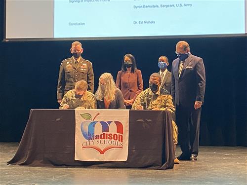 Ceremonial form signing with 3 military parents